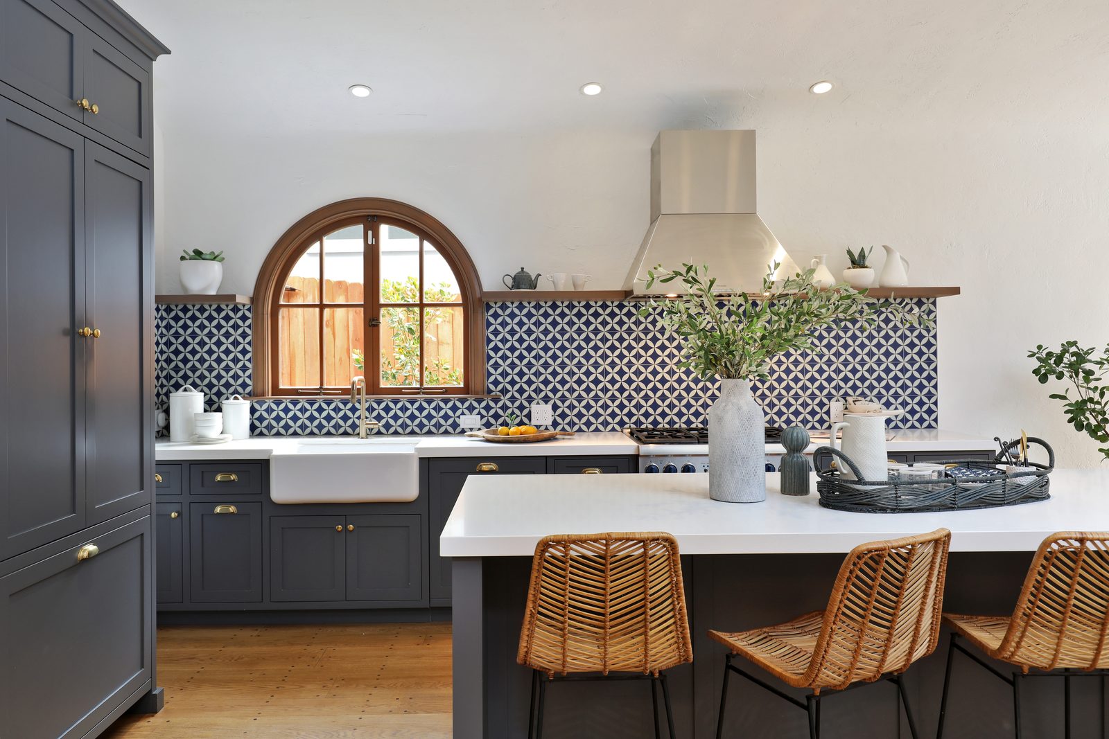 Renovated East Bay kitchen with arched wood window, blue cement tile, and marble island